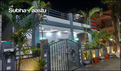 Beautifully decorated house with vibrant plants, modern gate, and Vastu-friendly design