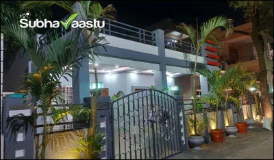 Beautifully decorated house with vibrant plants, modern gate, and Vastu-friendly design